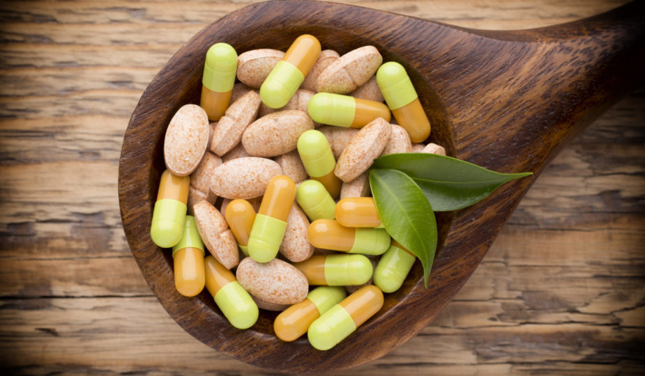 Vitamins on a wooden spoon