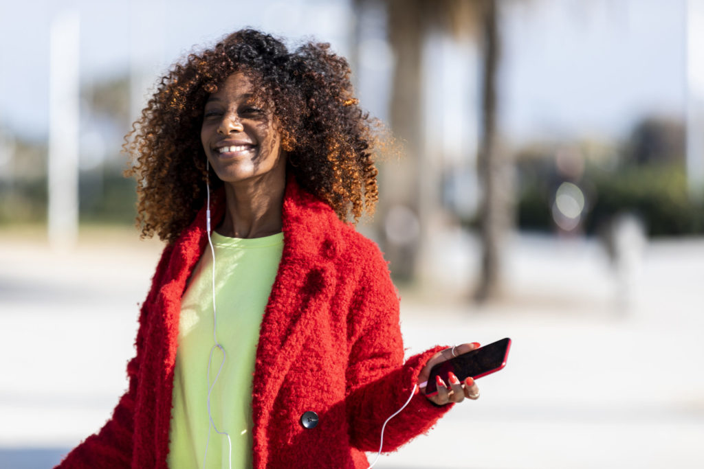 Young afro american woman laughing while dancing outdoors