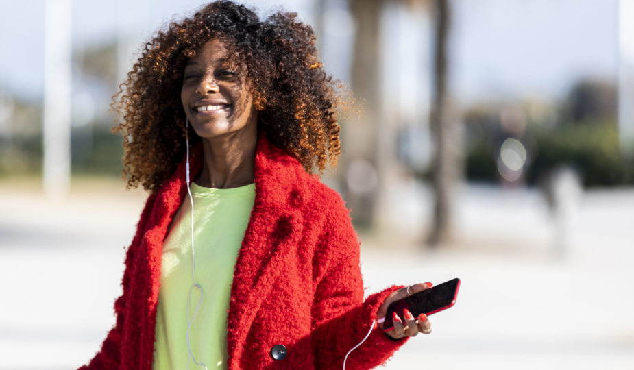 Young afro american woman laughing while dancing outdoors